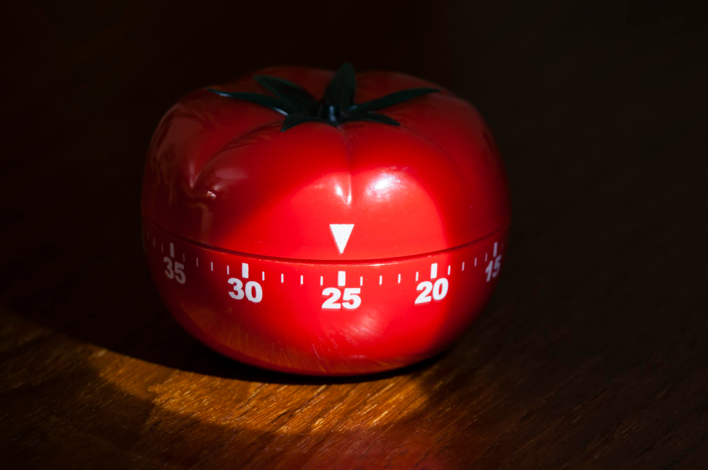 Timer clássico em forma de tomate simbolizando a técnica Pomodoro para estudar para Enem.
