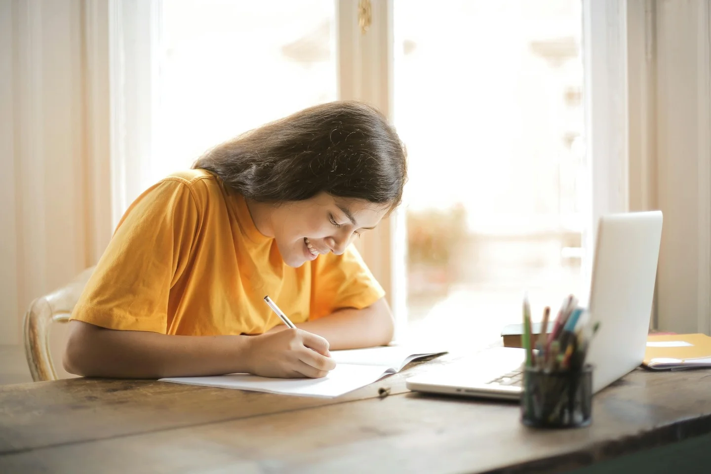Estudante aplicando na prática as estratégias de como começar a estudar para Medicina ENEM com caderno e computador