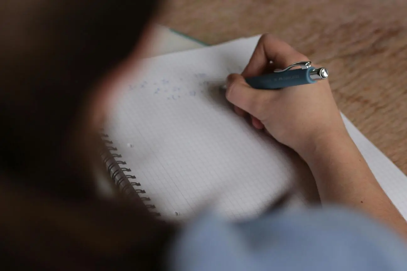 Estudante mantém a motivação e continua escrevendo no caderno mesmo em um dia difícil de preparação para o ENEM